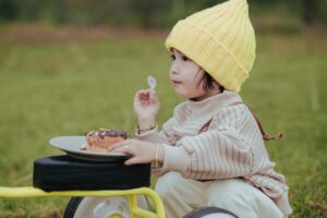 Kleinkind isst mit Kinderbesteck