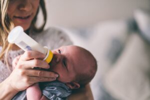 Mutter gibt Baby Flasche