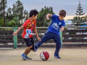 Zwei Jungs spielen Fußball in Jogginganzügen