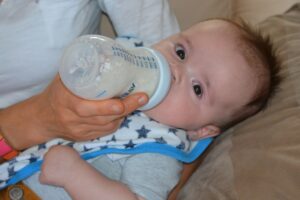 Milchpumpe Baby trinkt aus Flasche