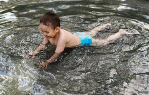 Kind mit Schwimmwindel im Wasser